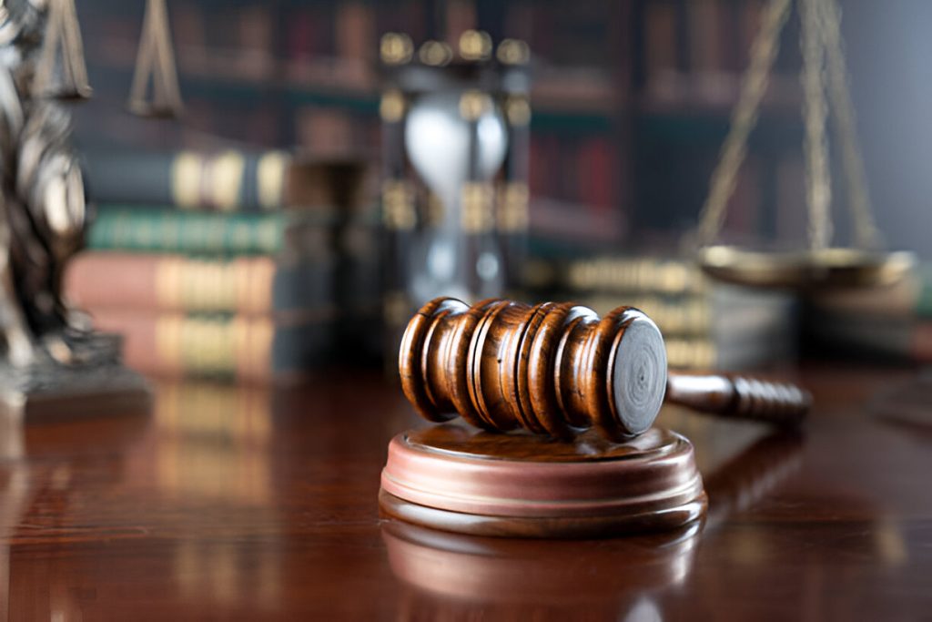 Wooden gavel on a polished desk, symbolizing legal authority and courtroom proceedings, with law books and a scale of justice in the background, reflecting Barry Hogen's criminal defense practice.