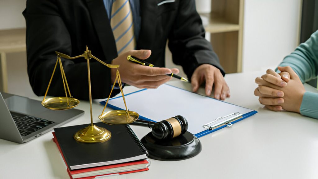 Lawyer discussing legal strategy with client, scales of justice and gavel on table, emphasizing criminal defense consultation.
